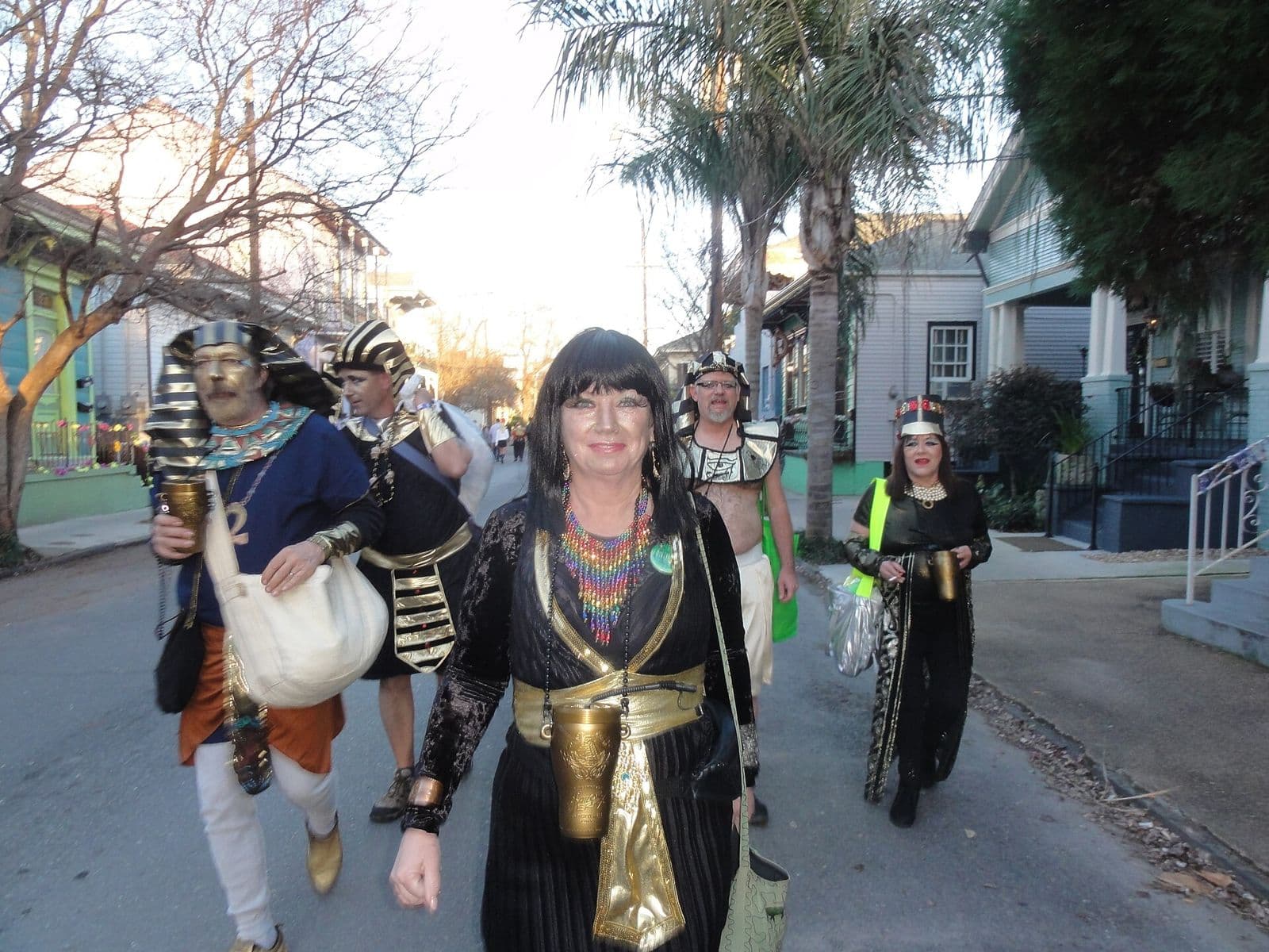Krewe du Vieux members in Egyptian-style costumes walking to line up for their parade at dusk