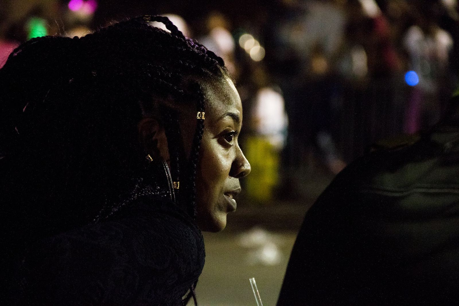 Spectator watching a night Mardi Gras parade in New Orleans
